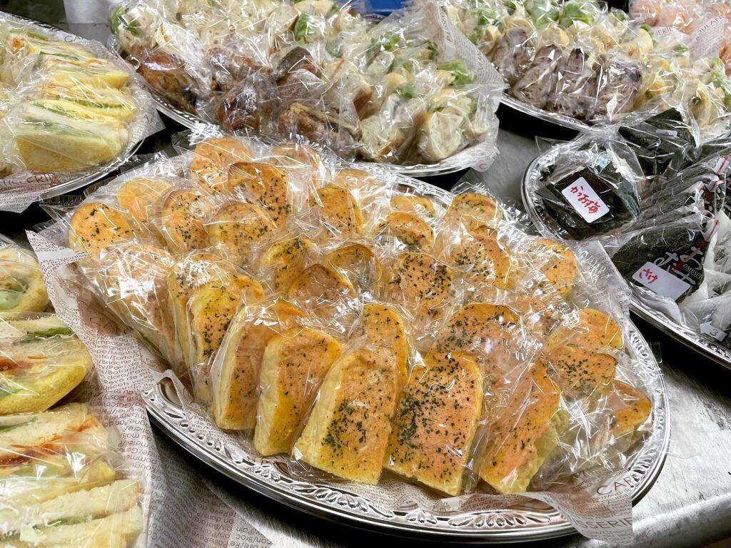 個包装のトーストやサンドイッチ、おにぎりを並べた様子