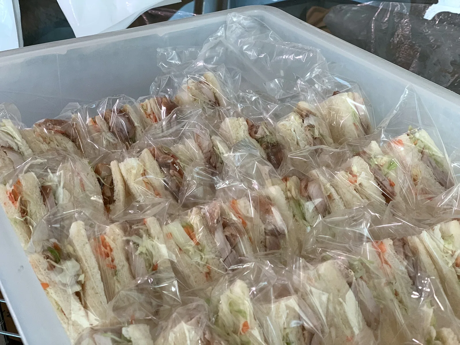 番重に詰めた個包装サンドイッチ