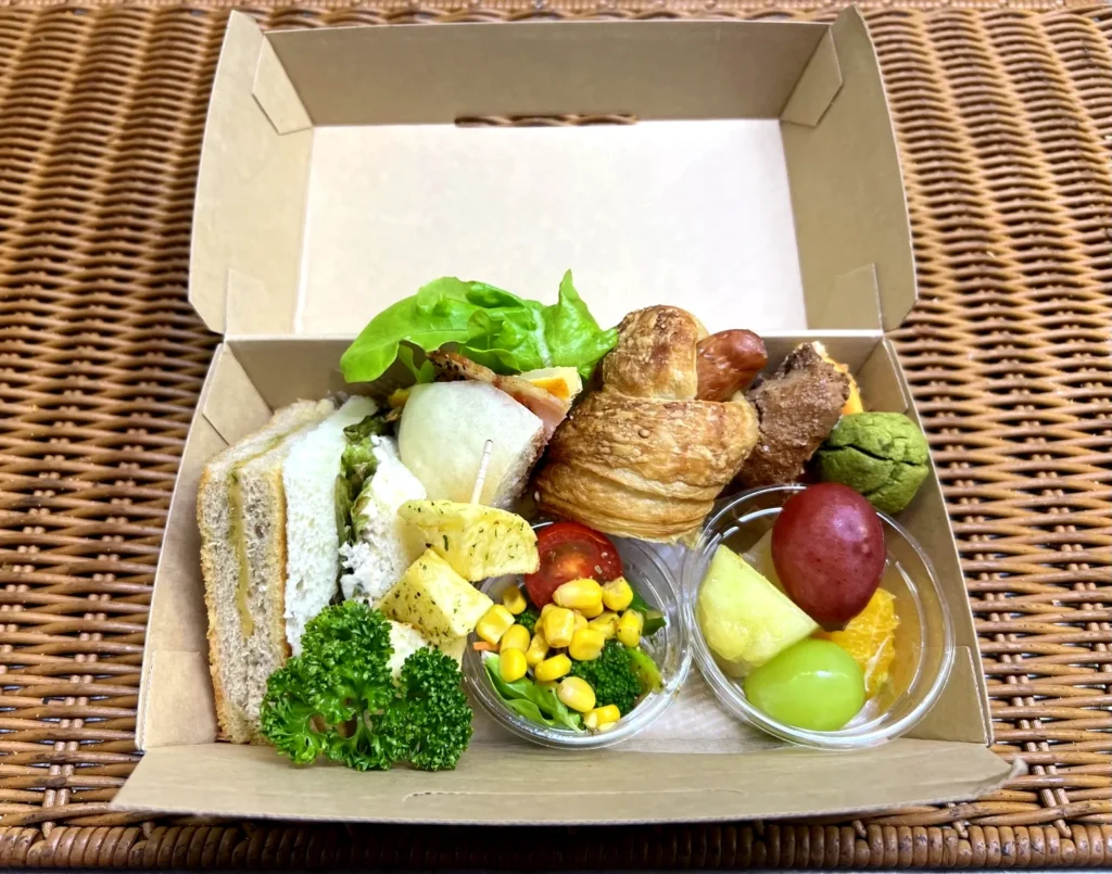 通常おまかせBOX(実写真):サンドイッチやパン、サラダ、フルーツ、ポテト、焼き菓子の詰め合わせ